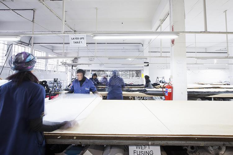 女工在服装厂展开纺织品高清图片下载-正版图片501876635-摄图网